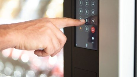 Finger beim Bedienen des Tastenfeldes an einem Einkaufsautomaten