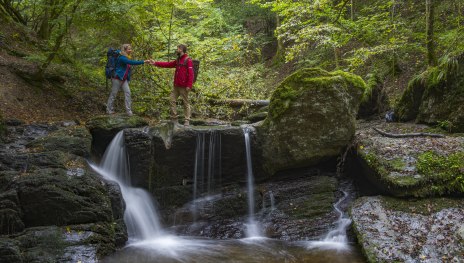 Paar an kleinem Wasserfall im Ehrbachtal | © Projektbüro Saar-Hunsrück-Steig, Klaus-Peter Kappest